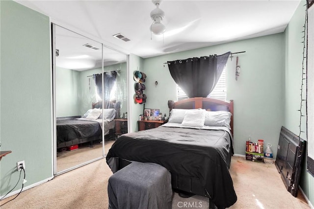 carpeted bedroom featuring a ceiling fan, a closet, visible vents, and baseboards