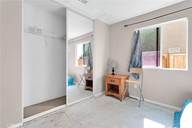 bedroom featuring a closet, unfinished concrete flooring, visible vents, and baseboards