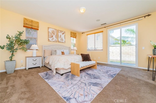 carpeted bedroom with access to exterior, visible vents, multiple windows, and baseboards