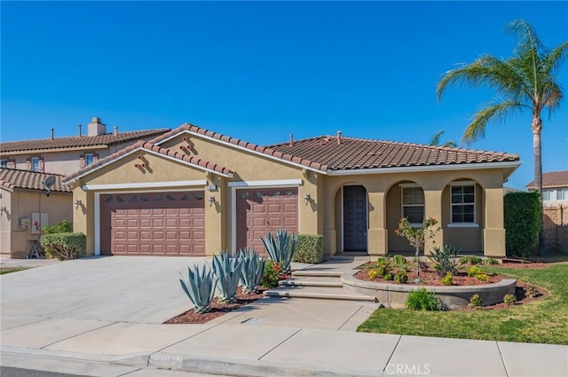 view of front of property with stucco siding, driveway, an attached garage, and a tile roof