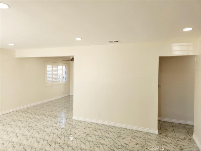 empty room with marble finish floor, recessed lighting, visible vents, and baseboards