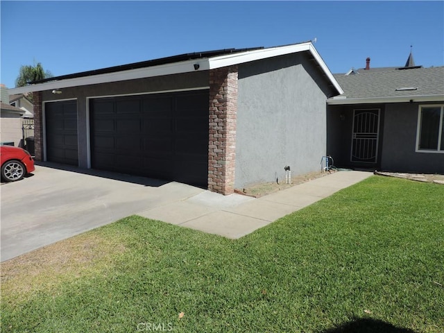 view of side of property featuring a garage, a yard, concrete driveway, and stucco siding