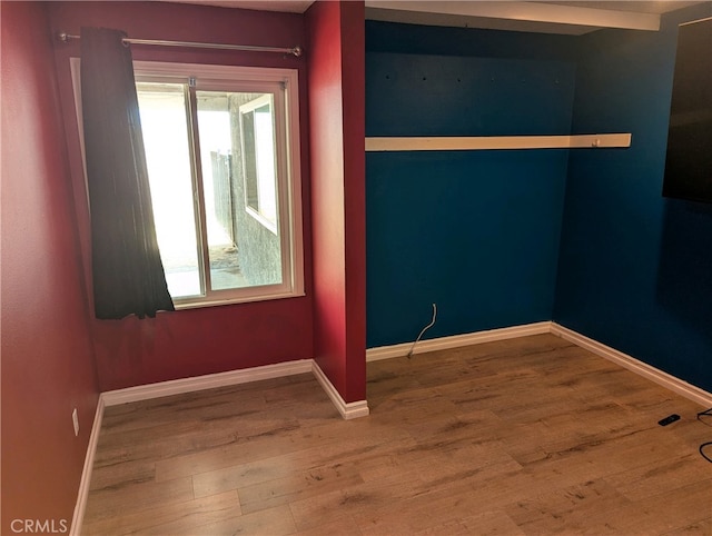 unfurnished room featuring wood finished floors and baseboards