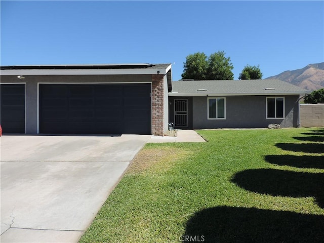 single story home featuring stucco siding, a front yard, a mountain view, a garage, and driveway