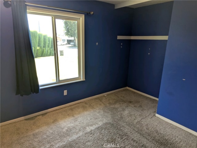 unfurnished room with carpet floors, a wealth of natural light, and baseboards