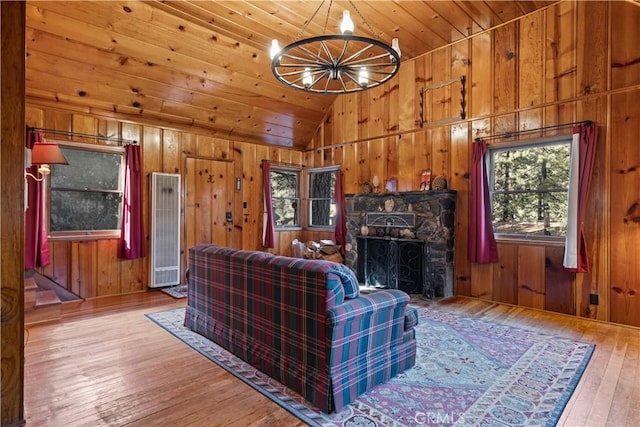 1779 Virginia St, Wrightwood, CA 92397 - living area with wooden ceiling, vaulted ceiling, a stone fireplace, light wood-type flooring, and wood walls