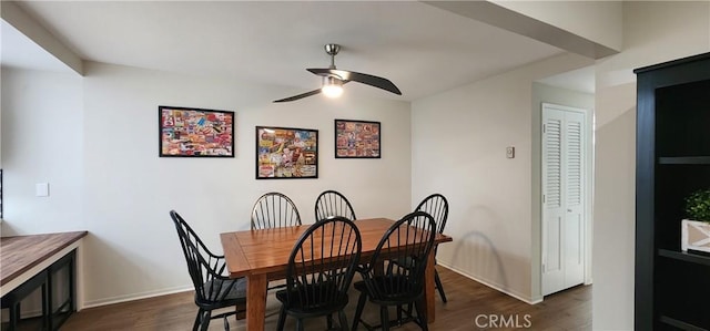 dining space featuring dark wood-style floors, ceiling fan, and baseboards