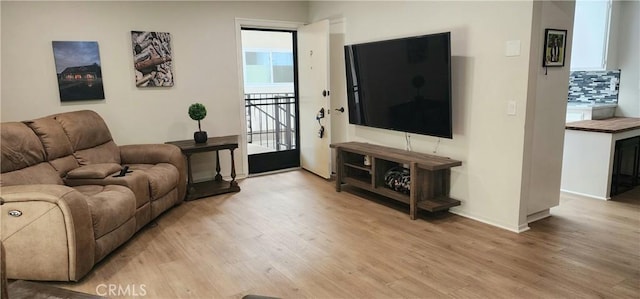 living room featuring light wood-type flooring and baseboards