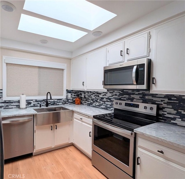 3311 Via Carrizo Unit P, Laguna Woods, CA 92637 - kitchen featuring stainless steel appliances, a skylight, a sink, and decorative backsplash