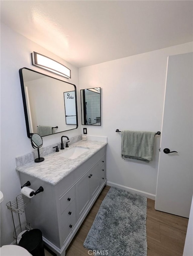 3311 Via Carrizo Unit P, Laguna Woods, CA 92637 - bathroom featuring toilet, vanity, wood finished floors, and baseboards