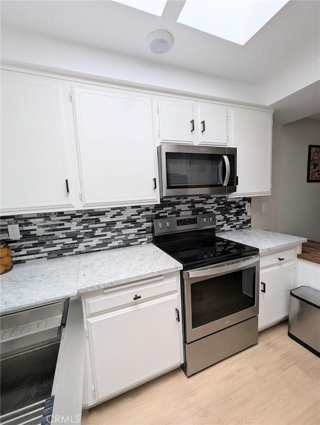 3311 Via Carrizo Unit P, Laguna Woods, CA 92637 - kitchen with stainless steel appliances, a skylight, and white cabinets