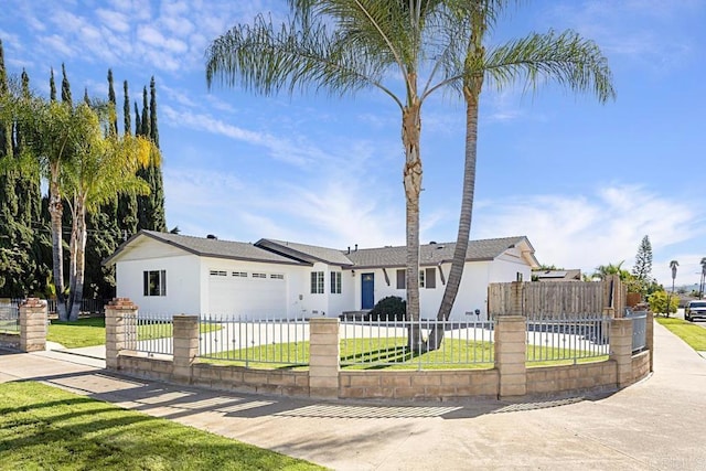 ranch-style house with a fenced front yard, a front lawn, and concrete driveway