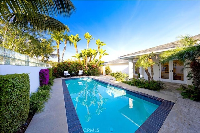 view of pool featuring french doors and a fenced backyard