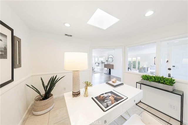 hall featuring a skylight, visible vents, baseboards, light tile patterned flooring, and recessed lighting