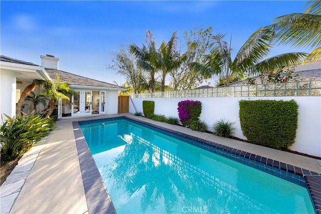 view of pool featuring a fenced backyard, a fenced in pool, and french doors