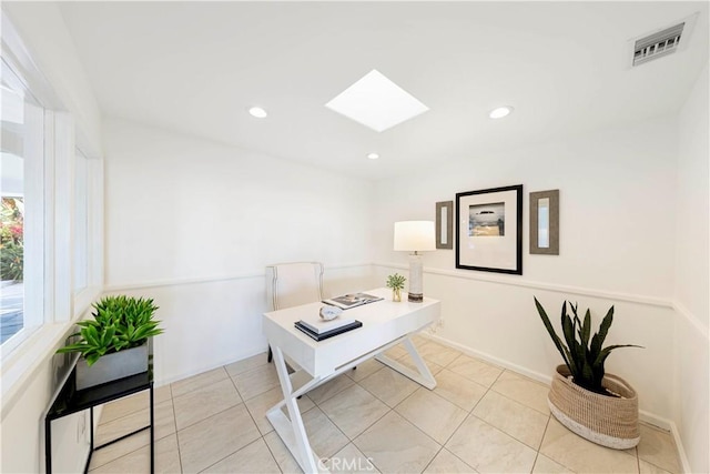 office featuring light tile patterned floors, recessed lighting, a skylight, visible vents, and baseboards