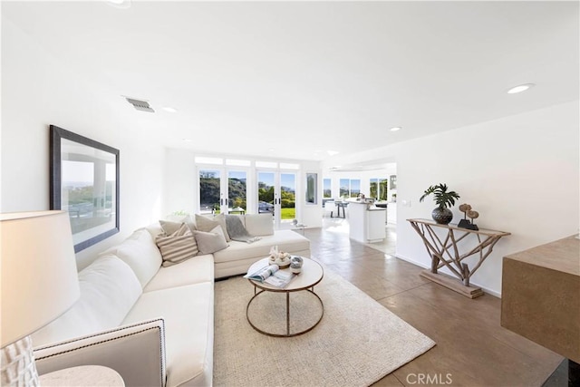 living room with recessed lighting, visible vents, and finished concrete flooring