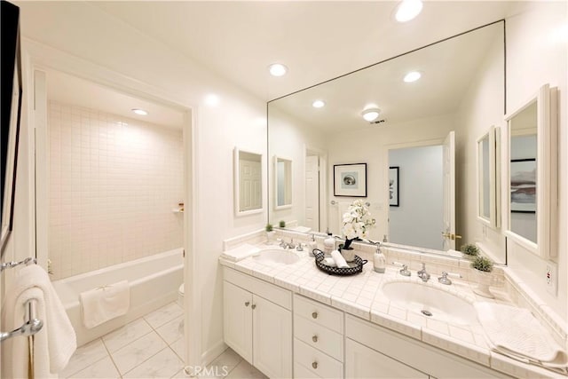 full bath with double vanity, a sink, toilet, and recessed lighting