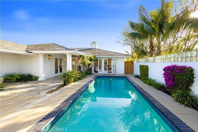 view of pool with french doors, fence, and a fenced in pool