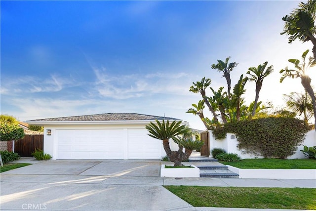 view of front facade featuring driveway, an attached garage, and stucco siding