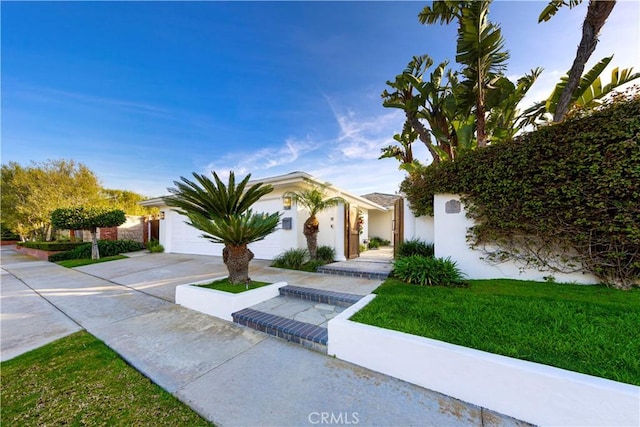 view of front facade featuring driveway, an attached garage, and a front yard