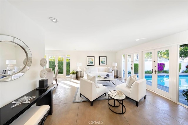 living area featuring recessed lighting, french doors, and finished concrete flooring