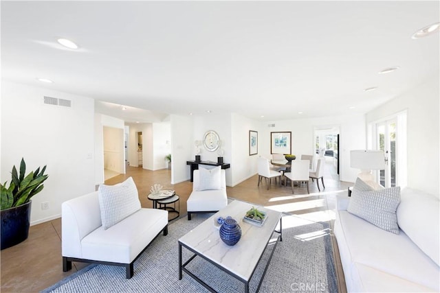 living room featuring baseboards, visible vents, and recessed lighting