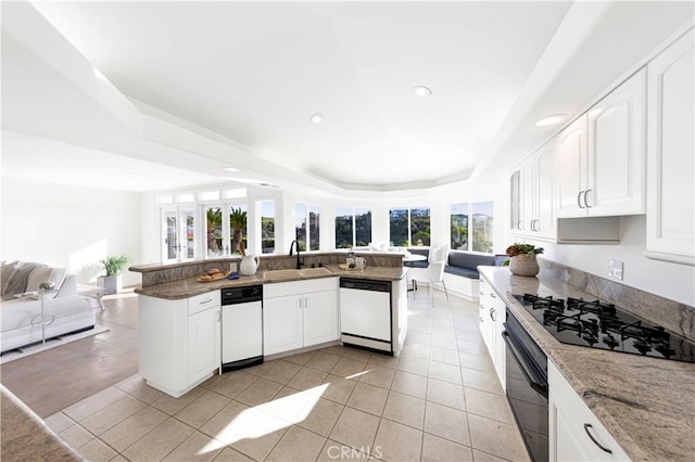 kitchen with open floor plan, white cabinetry, a sink, and black appliances