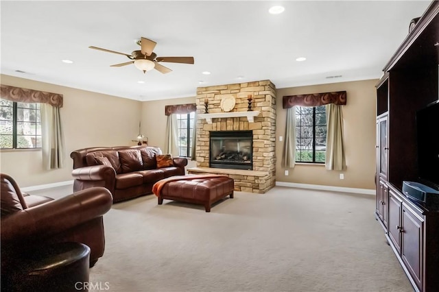 living room with a healthy amount of sunlight, a fireplace, light carpet, and baseboards