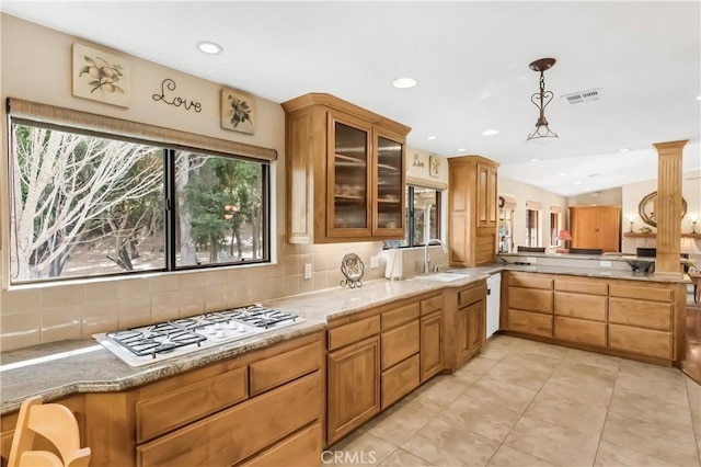 kitchen with white gas stovetop, tasteful backsplash, visible vents, glass insert cabinets, and a sink