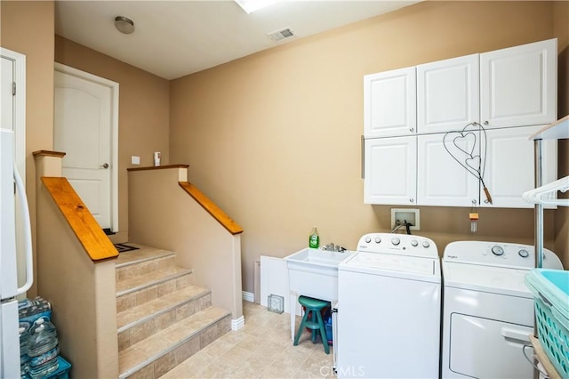 laundry area with visible vents, independent washer and dryer, and cabinet space