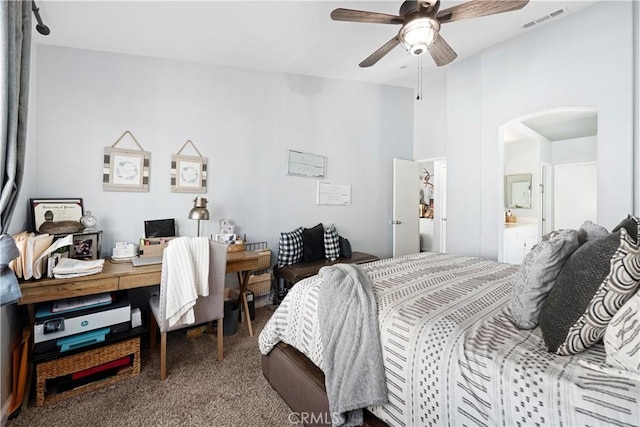 carpeted bedroom featuring arched walkways, visible vents, and a ceiling fan