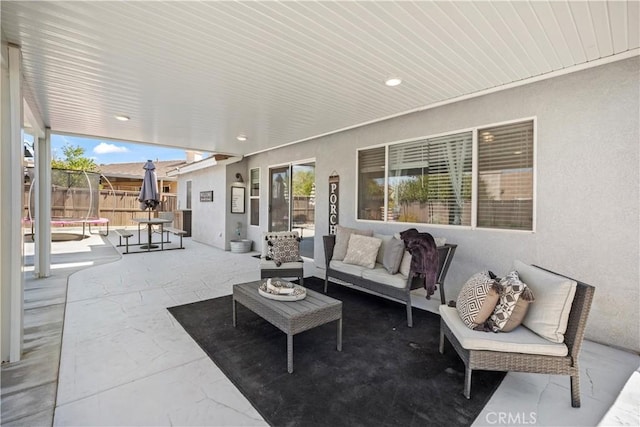 view of patio featuring a trampoline, fence, and an outdoor hangout area