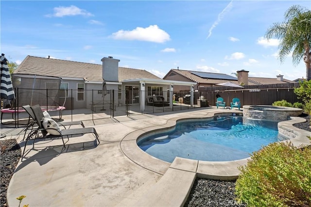 view of swimming pool featuring a fenced backyard, a pool with connected hot tub, and a patio