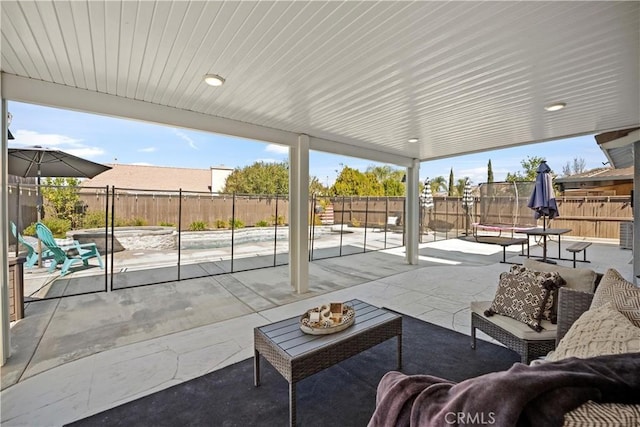 view of patio / terrace featuring a fenced backyard, a trampoline, and outdoor lounge area