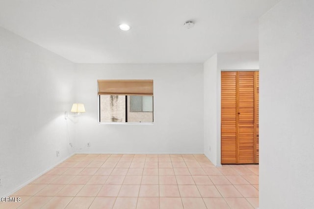 empty room with light tile patterned floors and recessed lighting