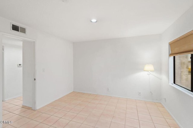 empty room with light tile patterned floors, visible vents, and recessed lighting