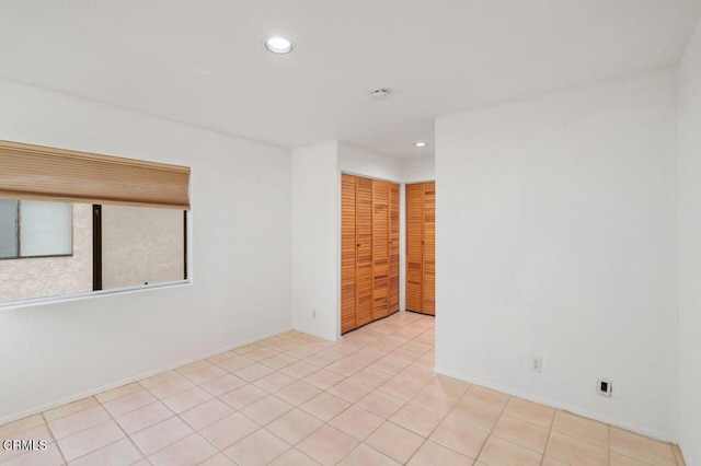 unfurnished room featuring light tile patterned floors and recessed lighting