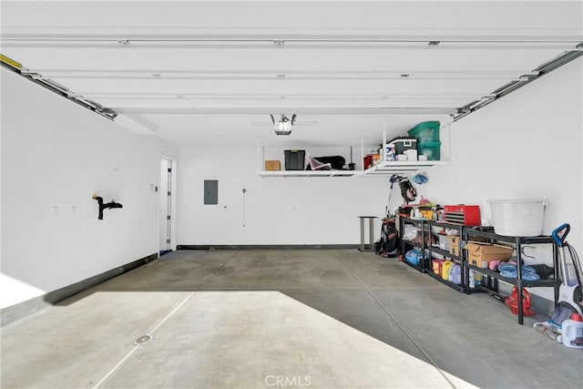 garage with a garage door opener, electric panel, and baseboards