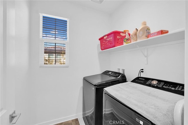 washroom featuring washer and dryer, laundry area, and baseboards