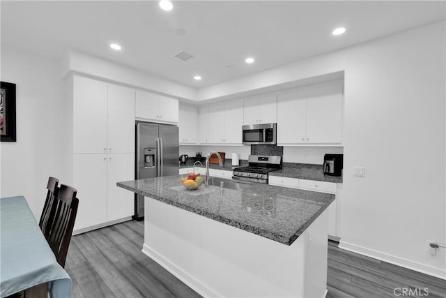 kitchen with recessed lighting, appliances with stainless steel finishes, dark wood-type flooring, white cabinetry, and a sink