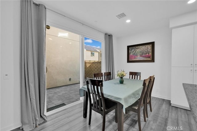 dining room with baseboards, visible vents, wood finished floors, and recessed lighting