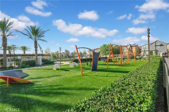 community jungle gym with a lawn and fence