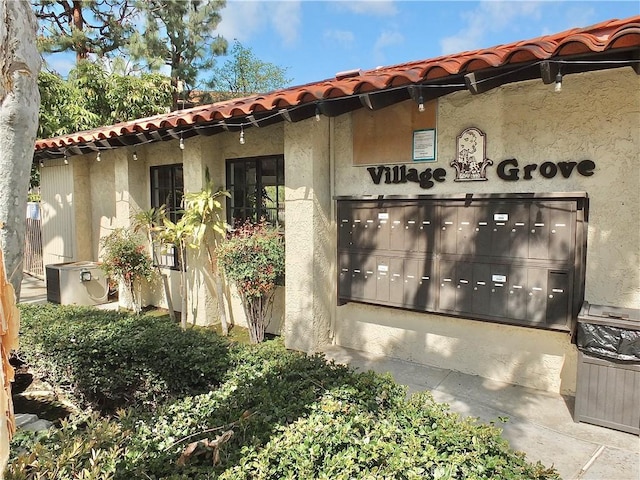 exterior space with a tile roof, cooling unit, and stucco siding