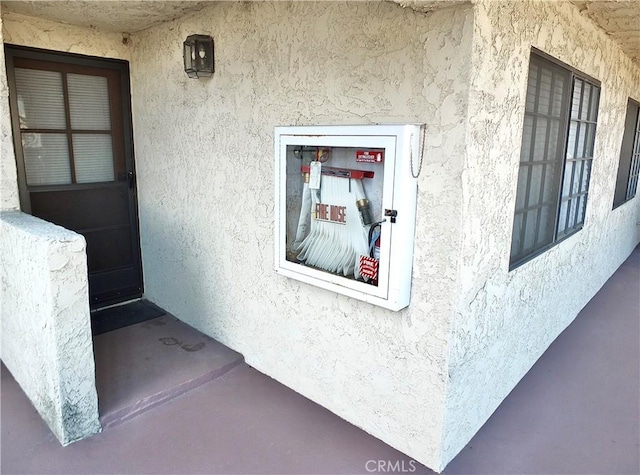 doorway to property featuring stucco siding