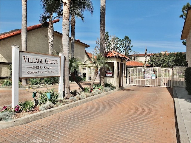 view of street with curbs, a gated entry, and a gate