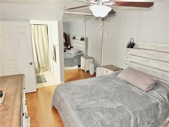 bedroom featuring light wood-type flooring, ceiling fan, and a closet