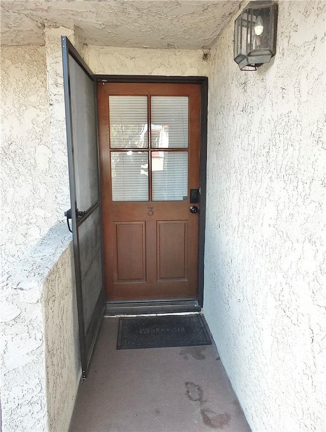 view of exterior entry featuring stucco siding