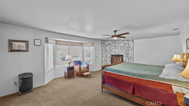 bedroom featuring ceiling fan, carpet floors, a fireplace, and visible vents