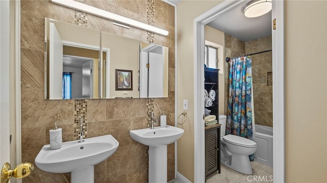 bathroom with toilet, a sink, tile walls, backsplash, and shower / bath combo